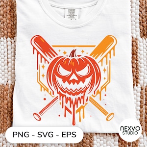 Może przedstawiać: Biały t-shirt z grafiką wyrzeźbionej dyni o groźnym wyrazie twarzy, umieszczonej przed dwoma skrzyżowanymi kijami baseballowymi. Projekt zawiera efekty ściekającej pomarańczowej farby oraz kształt bazy domowej w tle.