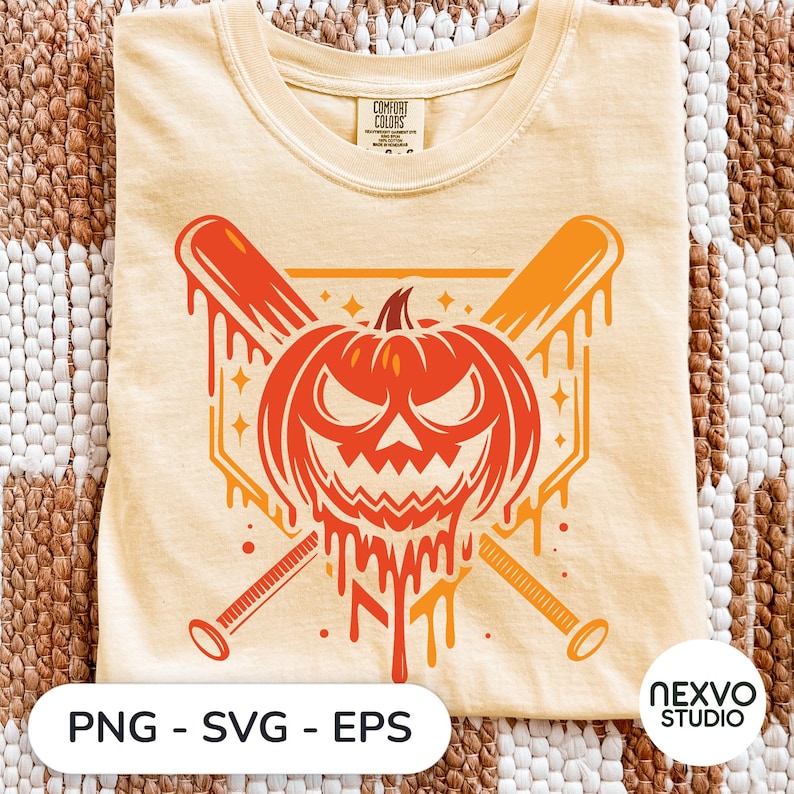 May include: A pale yellow t-shirt featuring a graphic of a melting orange pumpkin with a jagged, angry face positioned in front of two crossed baseball bats. The design includes small star accents and a geometric background shape behind the pumpkin.