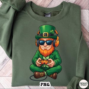 May include: Green sweatshirt featuring a cartoon leprechaun wearing sunglasses, headphones, and a green hat with a shamrock. The leprechaun is holding a game controller. The word "PNG" is printed at the bottom.