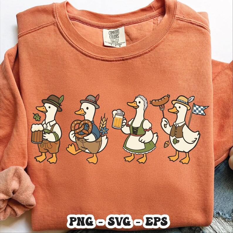 May include: An orange Comfort Colors sweatshirt featuring a cartoon design of four ducks dressed in traditional Bavarian attire. Each duck holds a beer stein, pretzel, sausage, or flag. The bottom of the shirt has the text "PNG - SVG - EPS".