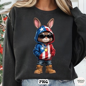 May include: A dark gray sweatshirt featuring a cartoon rabbit wearing sunglasses and a hoodie with a red, white, and blue design. The rabbit is also wearing blue jeans and brown boots. The image has a PNG watermark.