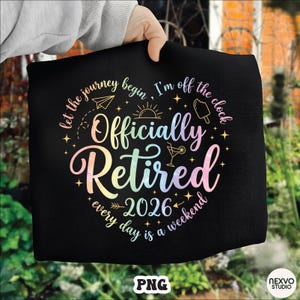 Könnte beinhalten: Schwarze Tragetasche mit dem Text "Officially Retired 2026" in einer bunten, regenbogenartigen Schriftart. Das Design enthält Illustrationen eines Papierfliegers, einer Sonne, eines Eis und eines Cocktails, mit den Sätzen "let the journey begin" und "every day is a weekend".