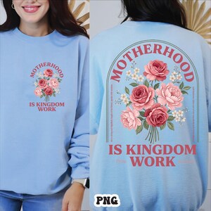 Peut inclure: Sweat-shirt bleu clair avec un motif de bouquet floral. L'avant pr&eacute;sente un bouquet de roses roses et rouges avec le texte "MOTHERHOOD IS KINGDOM WORK". Le dos a un motif floral plus grand et le m&ecirc;me texte.