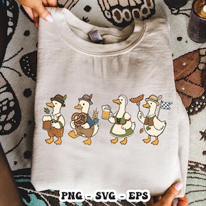 May include: A beige sweatshirt featuring a cartoon design of four ducks dressed in traditional Bavarian attire. Each duck is holding items like beer, pretzels, and sausages. The bottom of the sweatshirt has the text "PNG - SVG - EPS".