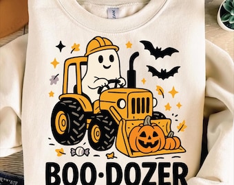 May include: Cream-colored sweatshirt with a Halloween-themed graphic. The design features a ghost driving a yellow bulldozer with a pumpkin bucket, the text "BOO-DOZER", bats, stars, and pumpkins. The bottom of the shirt has the text "PNG SVG EPS".