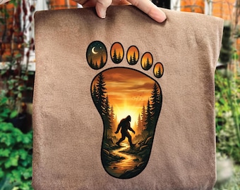 Ślad stopy Bigfoota w formacie PNG, projekt zachodu słońca w lesie Sasquatcha, zabawna grafika z wędrówek na kempingu, zabytkowa Bigfoot, cyfrowy download Cryptid Lover