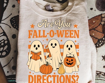 May include: A light beige sweatshirt with the text "Are You FALL-O-WEEN DIRECTIONS?" in orange. The design features three cartoon ghosts, pumpkins, and the text "PNG - SVG - EPS".