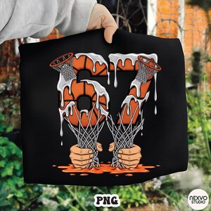 May include: Black graphic design featuring the number 67 in orange basketballs with white dripping paint. Basketball nets are held by hands at the bottom. The word "PNG" is at the bottom left.