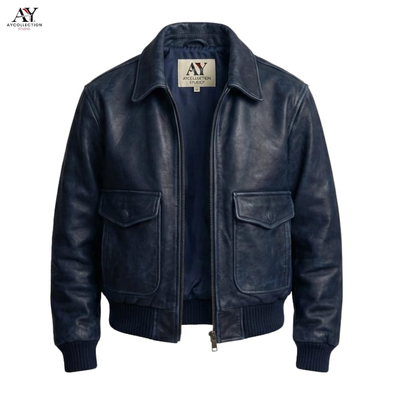 May include: A navy blue leather jacket with a collared neckline, two front pockets, and a ribbed hem and cuffs. The jacket has a zipper closure and a label with the text "AY ANCELLATION STUDIO".
