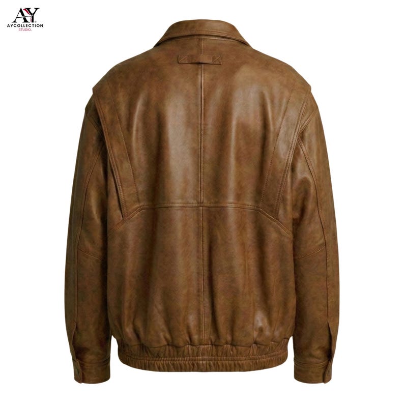 Puede incluir: Chaqueta de cuero marr&oacute;n con un dise&ntilde;o cl&aacute;sico. La chaqueta presenta un cuello, pu&ntilde;os abotonados y un dobladillo acanalado. La vista trasera muestra el ajuste entallado y las costuras detalladas. El cuero tiene un aspecto envejecido.