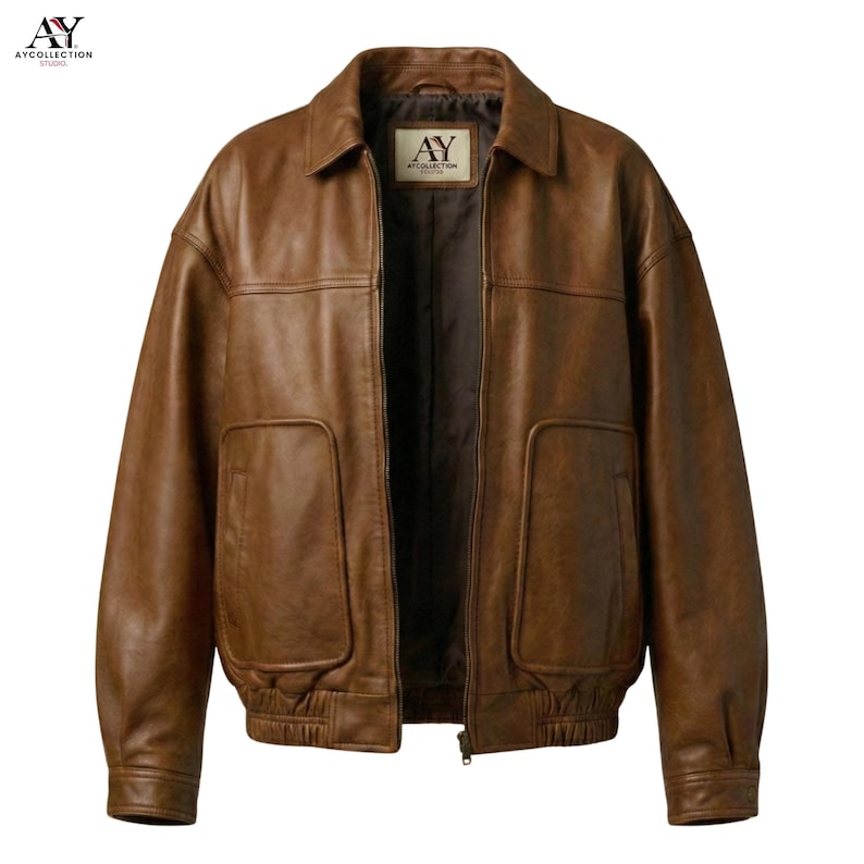 Puede incluir: Chaqueta de cuero marr&oacute;n con cuello, dos bolsillos delanteros y cierre de cremallera. La chaqueta tiene un estilo bomber cl&aacute;sico con dobladillo y pu&ntilde;os de canal&eacute;. La etiqueta dice "AY COLLECTION STUDIO".