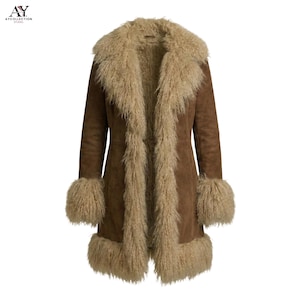 May include: A brown suede coat with a beige shearling lining and trim. The coat features a wide collar, cuffs, and hem with the shearling. The coat is a long, knee-length style.