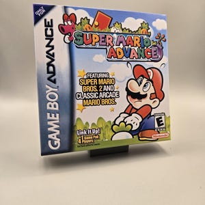 May include: A Super Mario Advance Game Boy Advance game cartridge. The box art features Mario in a red hat and blue overalls. The game title is in a colorful font. The box also includes the text "Featuring Super Mario Bros. 2 and Classic Arcade Mario Bros."