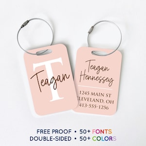 May include: Two pink luggage tags with silver wire loops. One tag features the name "Teagan" with a large white "T". The other tag displays "Teagan Hennessey" and an address. Text at the bottom reads "FREE PROOF • 50+ FONTS DOUBLE-SIDED • 50+ COLORS".