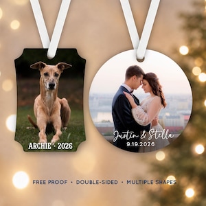 May include: Two hanging ornaments with white ribbons. The left ornament is rectangular with curved sides, featuring a brown dog and the text ARCHIE 2026. The right ornament is circular, featuring a couple and the text Justin & Stella 9.19.2026.