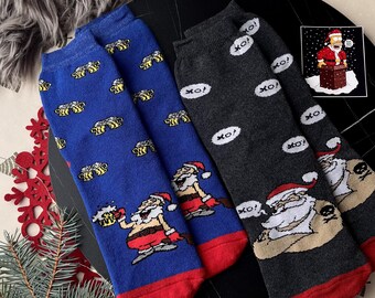 May include: Four pairs of Christmas-themed socks. Two pairs are blue with Santa Claus and beer graphics, and two are gray with "XO!" speech bubbles and Santa Claus with a skull. All socks have red toes.