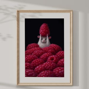 May include: A framed print featuring a white mouse holding a large red raspberry above its head, surrounded by a pile of other raspberries. The background is black, and the print is in a light-colored wooden frame.