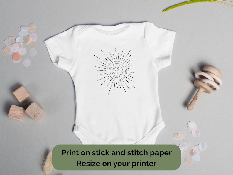 K&ouml;nnte beinhalten: Wei&szlig;er Baby-Body mit schwarzem Sonnenmuster. Die Sonne hat eine spiralf&ouml;rmige Mitte und strahlenf&ouml;rmige Linien. Der Text auf dem Bild lautet: "Auf Stick- und Stichpapier drucken. Gr&ouml;&szlig;e auf Ihrem Drucker &auml;ndern."
