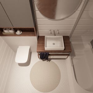 Puede incluir: Interior de ba&ntilde;o moderno con inodoro, lavabo y ba&ntilde;era blancos. El lavabo est&aacute; sobre un mueble de madera con un grifo cromado. Una alfombra redonda beige est&aacute; en el suelo. Un armario gris y un espejo est&aacute;n montados en la pared.