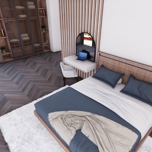 Puede incluir: Un dormitorio moderno con una cama con estructura de madera, edred&oacute;n y almohadas azules. Tambi&eacute;n se ven una alfombra blanca y un armario de madera. Un peque&ntilde;o escritorio con un port&aacute;til y una silla est&aacute; junto a la cama.