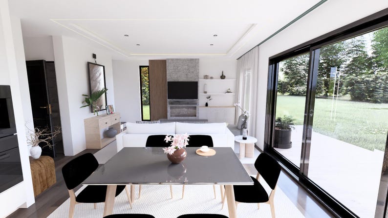 Op de afbeelding: Een moderne woonkamer met een eethoek. De eettafel is grijs met zwarte stoelen. Een witte bank staat tegenover een aan de muur gemonteerde tv. Grote ramen bieden uitzicht op de buitenwereld. De kamer is ingericht in neutrale tinten.