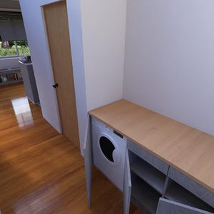 May include: Interior view of a utility room with a washing machine and a wooden countertop. The room has a light colour scheme with wooden flooring and a door leading to another room. A framed picture hangs on the wall.