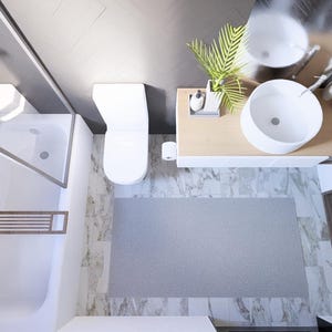 May include: An overhead view of a modern bathroom with a white toilet, sink, and shower. A grey rug sits on the floor. A washing machine is in a wooden cabinet. The walls are marble and grey.