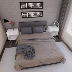Peut inclure: Chambre avec lit recouvert d'une couette beige et d'une couverture grise. Deux tables de chevet blanches avec lampes et fleurs de chaque c&ocirc;t&eacute;. La pi&egrave;ce a une grande fen&ecirc;tre et deux tableaux encadr&eacute;s au mur.