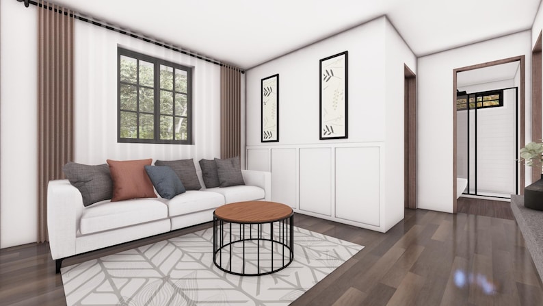 May include: A modern living room with a white sofa, colorful throw pillows, and a round coffee table. The room features a geometric patterned rug, artwork, and a window with a view of trees. The walls are white, and the floors are wood.