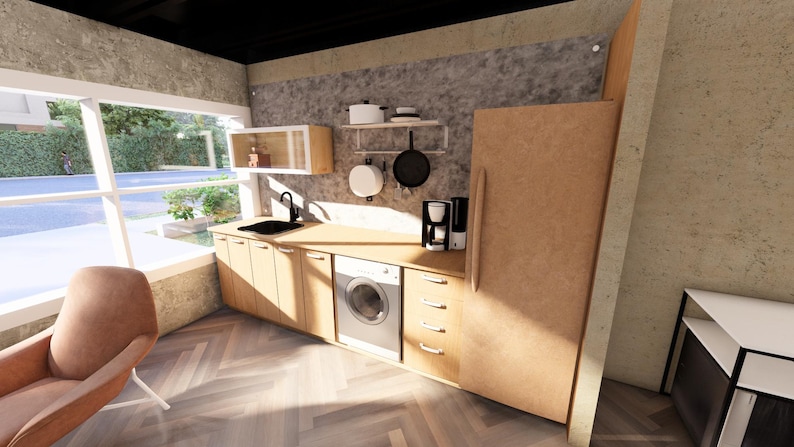 May include: A modern kitchen with light wood cabinets, a black sink, and a stainless steel washing machine. Appliances include a coffee maker, a refrigerator, and a hanging pot and pan rack. A brown armchair sits near a large window.