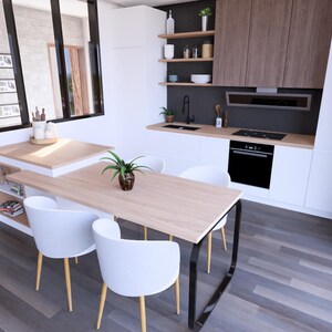 Peut inclure: Int&eacute;rieur de cuisine moderne avec des meubles blancs, des accents en bois et une table &agrave; manger avec des chaises blanches. La cuisine comprend un four encastr&eacute;, une plaque de cuisson et une petite plante sur la table. Le sol est en bois gris fonc&eacute;.