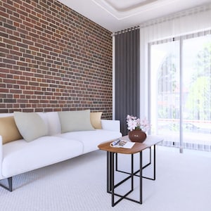 May include: A modern living room with a white sofa, pillows, and a wooden coffee table with a black metal frame. The room features a brick wall, dark gray curtains, and a large window with natural light.