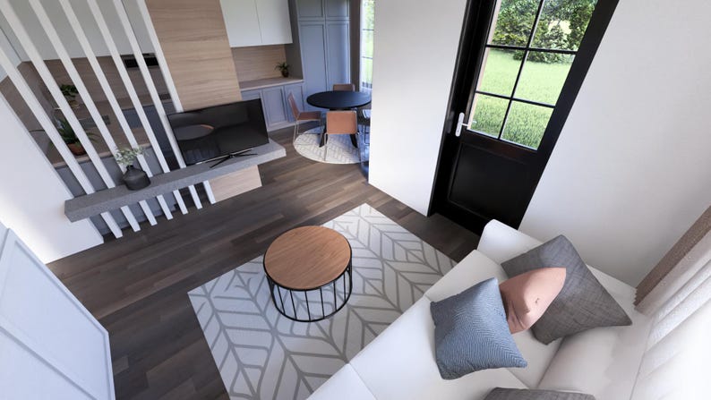 May include: An overhead view of a modern living space with a white sofa, patterned rug, and a round wooden coffee table. A black TV is mounted on a gray shelf. A black door with a window leads to a green outdoor space.