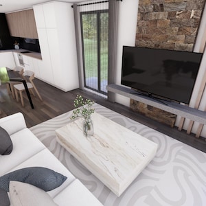 Puede incluir: Un sof&aacute; blanco con almohadas negras se encuentra en una sala de estar con una mesa de caf&eacute; blanca y una alfombra blanca. Un televisor de pantalla plana est&aacute; montado en la pared sobre una chimenea de piedra.