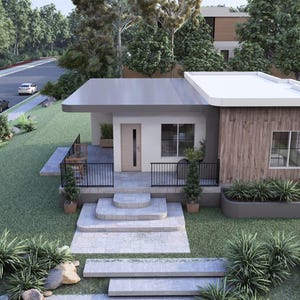 May include: An aerial view of a modern, single-story house with a flat roof and a minimalist design. The house features a combination of white, gray, and wood paneling, with a small porch and a well-manicured lawn. Cars are visible on the street.