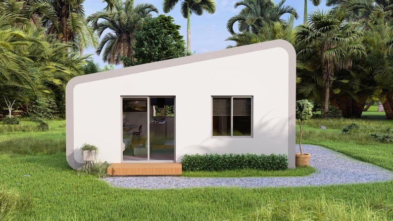 May include: A contemporary, white, single-storey house with a grey roof and curved edges. It features a sliding glass door and a window. The house is set in a verdant landscape of grass and palm trees, with a gravel path leading to the entrance.