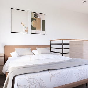 K&ouml;nnte beinhalten: Ein modernes Schlafzimmer mit einem Bett, Kissen und einer gemusterten Bettdecke. Ein Nachttisch mit einer Lampe steht neben dem Bett. Zwei gerahmte Kunstwerke schm&uuml;cken die Wand. Eine gro&szlig;e Kommode befindet sich im Hintergrund.