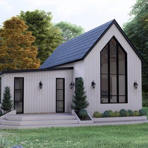 K&ouml;nnte beinhalten: Ein modernes wei&szlig;es Haus mit einem dunkelblauen Dach und schwarzen Fensterrahmen. Das Haus hat ein gro&szlig;es, bogenf&ouml;rmiges Fenster und ist von B&auml;umen und gr&uuml;nem Gras umgeben. Au&szlig;enleuchten sind an den W&auml;nden angebracht.