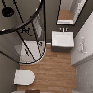 May include: An overhead view of a modern bathroom with a black-framed shower enclosure, a white toilet, and a vanity with a mirror. The floor is wood-toned, and the walls are painted in neutral colors. The shower head is black.