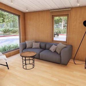 May include: Interior of a modern living room with wood paneling and a large window. A grey sofa with cushions sits opposite a round coffee table. A black floor lamp and a white chair complete the space.