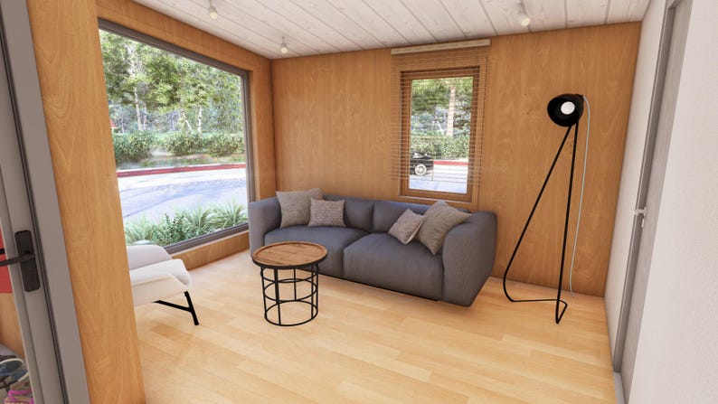 May include: Interior of a modern living room with wood paneling and a large window. A grey sofa with cushions sits opposite a round coffee table. A black floor lamp and a white chair complete the space.