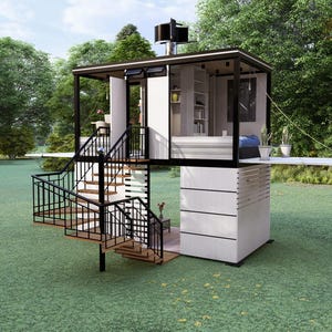 Op de afbeelding: Een modern, tweelaags tiny house met een zwart frame en witte buitenkant. Het huis heeft een wenteltrap, een klein balkon en een dakconstructie. Het staat op een groen gazon met bomen op de achtergrond.