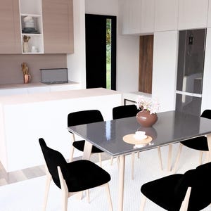 Op de afbeelding: Een moderne keuken en eetkamer met witte kasten, een wit eiland en een grijze eettafel. Zwarte stoelen omringen de tafel en een vaas met bloemen staat in het midden. De keuken heeft roestvrijstalen apparaten.