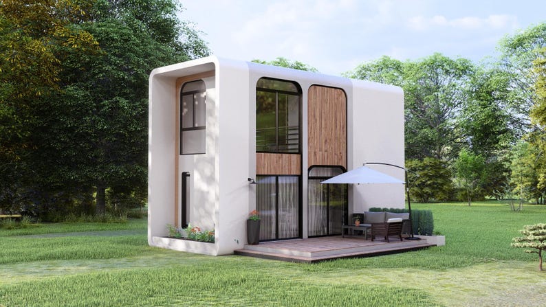 May include: Contemporary two-storey white house with large windows and wooden panels. Includes a small patio with outdoor furniture and a white parasol. Situated on a green lawn surrounded by trees.