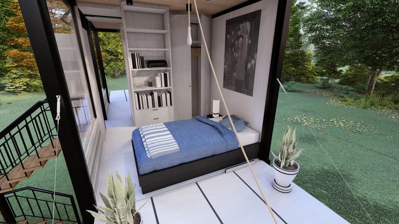 Op de afbeelding: Interieur van een moderne slaapkamer met een bed, boekenkast en groot raam. Het bed heeft een blauw dekbed en een gestreepte deken. Een zwart-wit kunstwerk hangt aan de muur. Een potplant staat op de vloer.