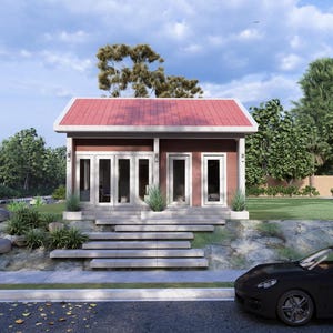 May include: A small, modern building with a red roof and white trim. The building has multiple glass doors and windows. A black car is parked in front of the building on a paved road. Landscaping includes bushes, rocks, and trees.