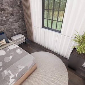 May include: Bedroom interior with a bed, pillows, and a patterned blanket. A round rug sits on the floor. A window with a view of the outside is visible. A potted plant is in the corner.