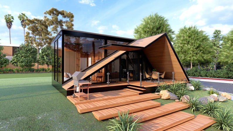 May include: Modern, geometric house with a wooden deck and walkway. The house features large glass windows, a sloped roof, and a built-in grill. Landscaping includes grass, rocks, and plants, with a blue sky in the background.