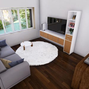 May include: An interior shot of a modern living room with a gray sectional sofa, a white round rug, and a wooden coffee table. A large TV is mounted on a wooden cabinet. A record player sits on a wooden side table. A large window provides natural light.