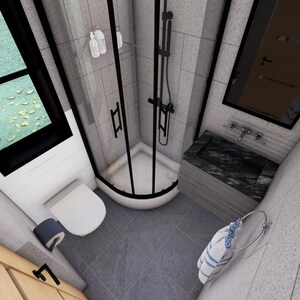 May include: A modern bathroom with a black-framed shower, a white toilet, and a dark countertop sink. The shower has a curved glass door. A window is visible in the upper left corner. The walls are light gray.